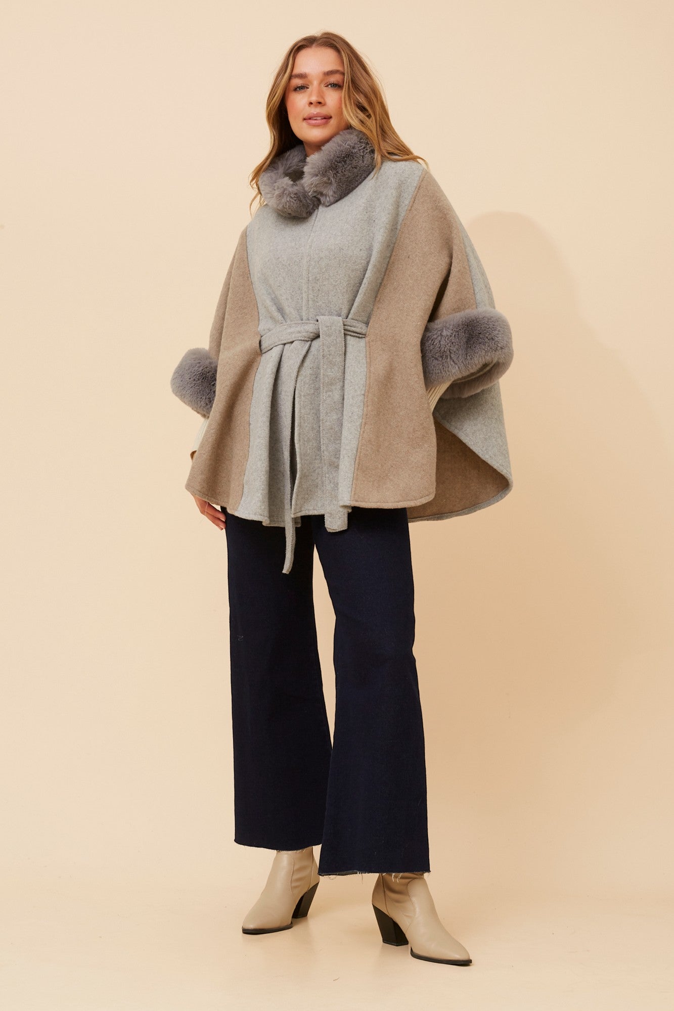 Image of a model wearing Outerwear. Product name - RYLAN FAUX FUR TRIM PONCHO in Grey colour by brand - Caroline Morgan Australia