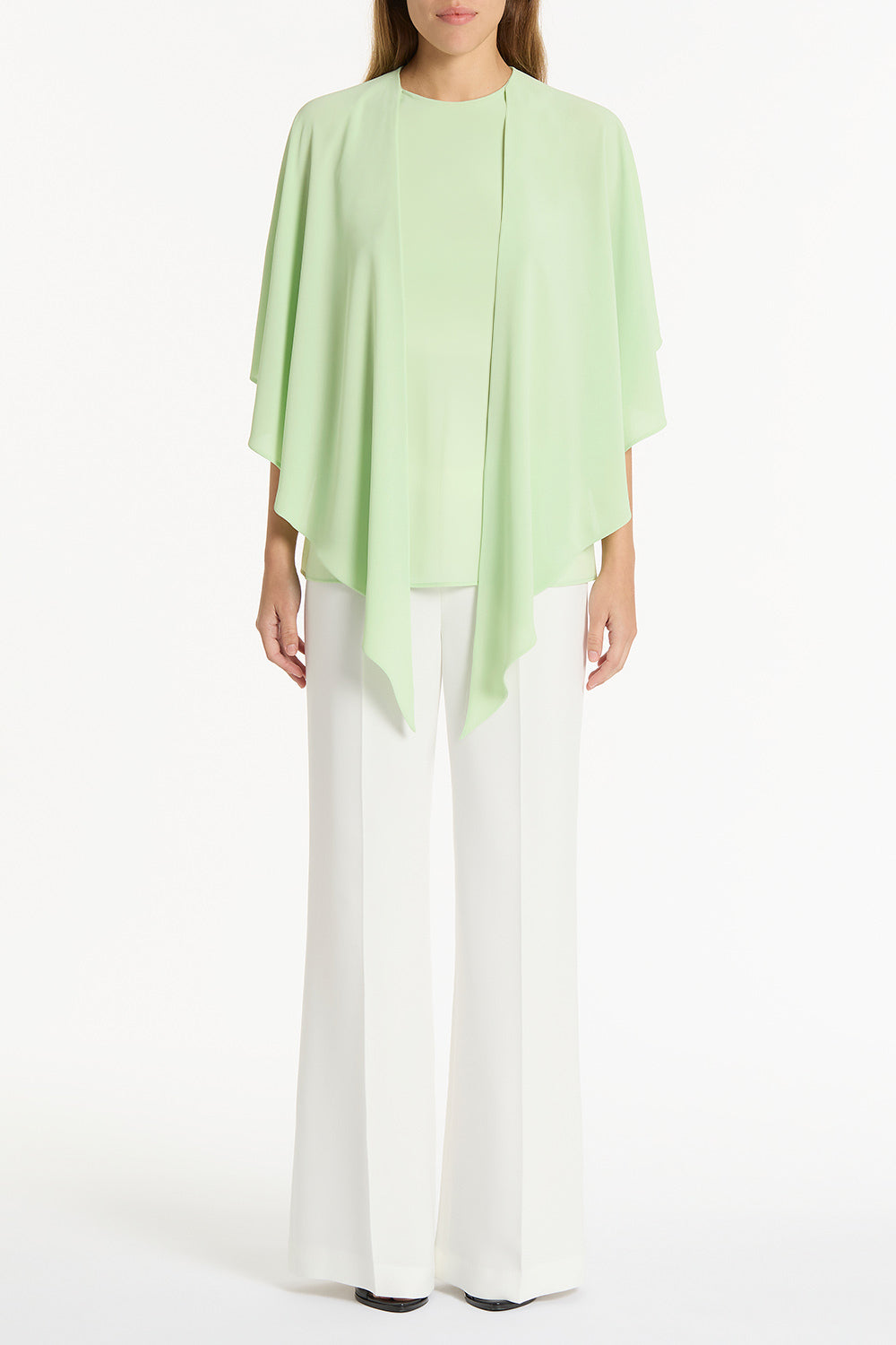 Image of a model wearing Tops. Product name - Peridot Georgette Cascata Top in Green colour by brand - Carla Zampatti