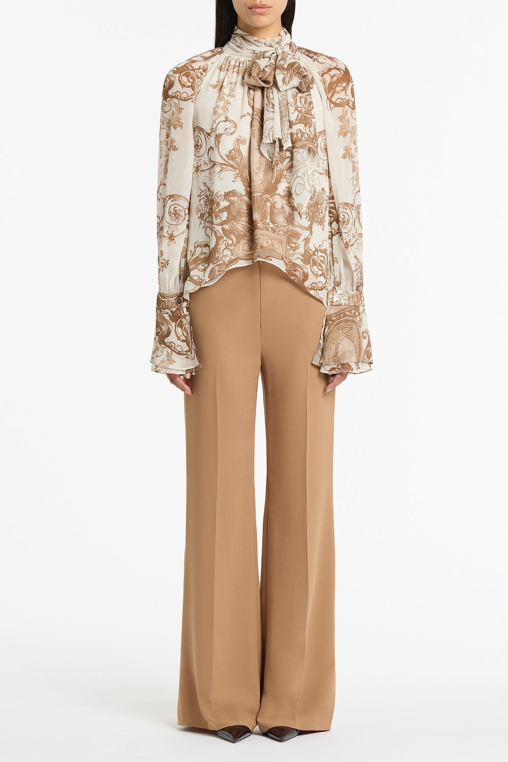 Image of a model wearing Tops. Product name - Renaissance Georgette High Low Blouse in Natural colour by brand - Carla Zampatti