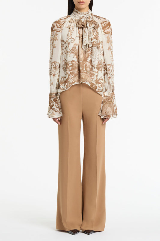 Image of a model wearing Tops. Product name - Renaissance Georgette High Low Blouse in Natural colour by brand - Carla Zampatti