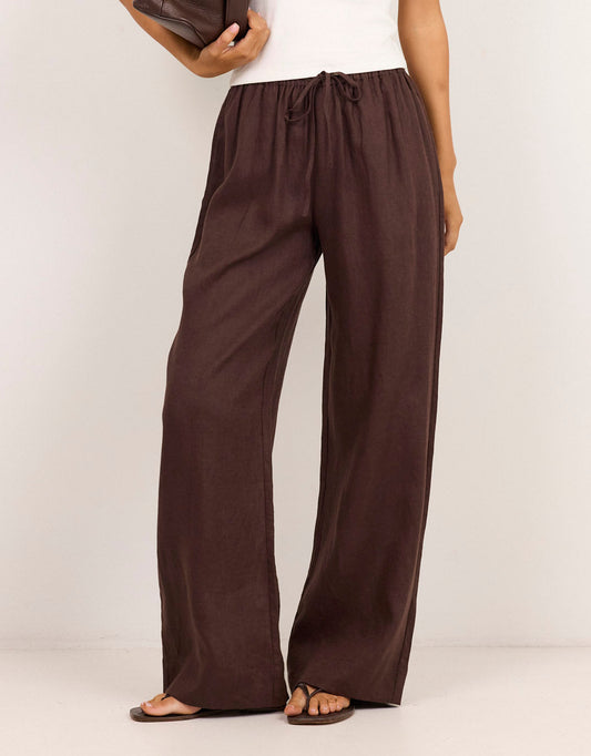 Image of a model wearing Pants. Product name - Wellness Pull On Wide Leg Pants Chocolate in Chocolate colour by brand - Re:Union The Label