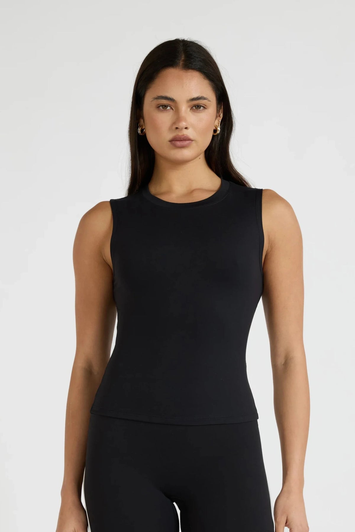 Image of a model wearing Tops. Product name - ALLFENIX CloudCore Lite Active Tank in Tan colour by brand - All Fenix