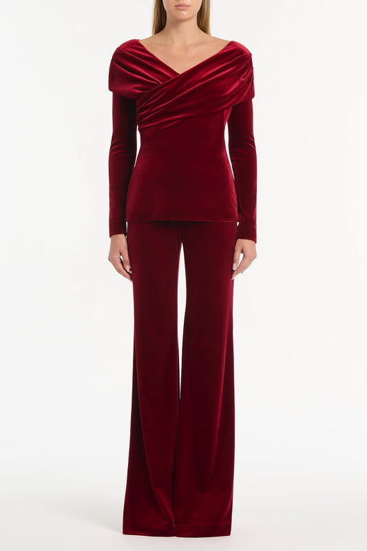 Image of a model wearing Tops. Product name - Rouge Velvet Draped Shoulder Top in Red colour by brand - Carla Zampatti