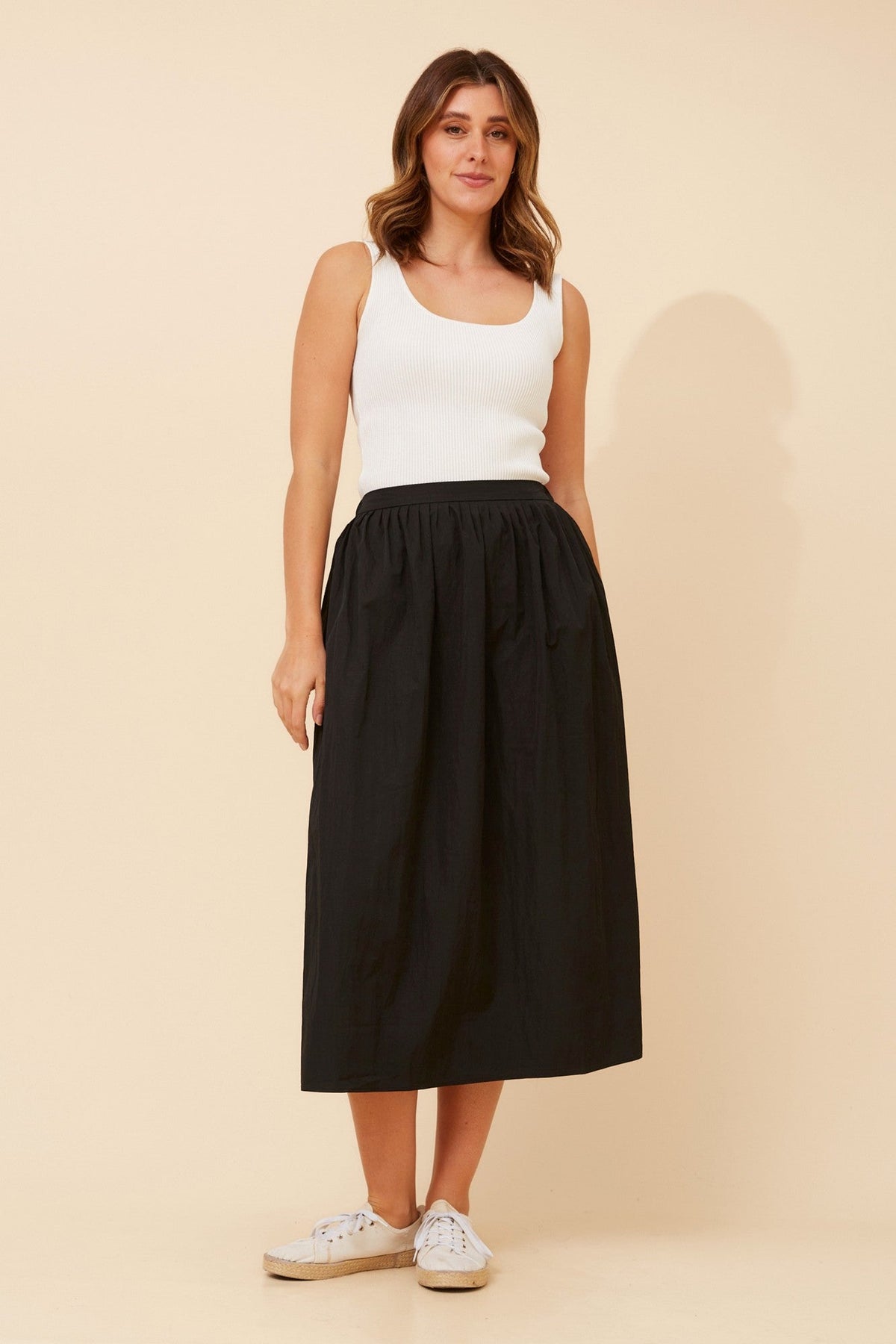 Image of a model wearing Skirts. Product name - HADI SOLID MIDI SKIRT in Black colour by brand - Caroline Morgan Australia