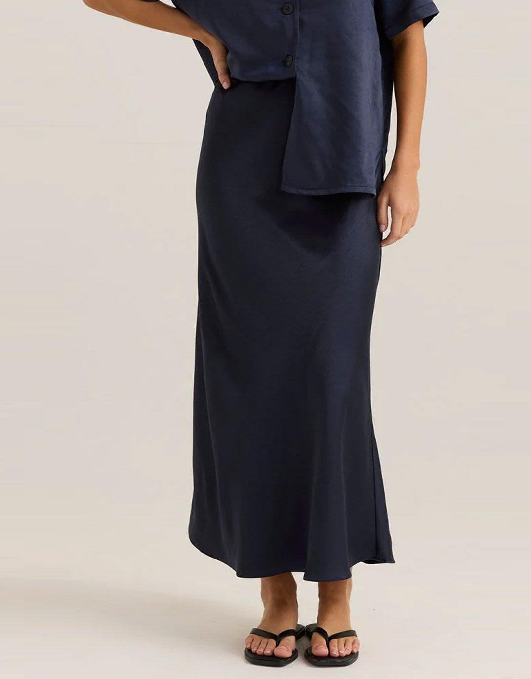 Image of a model wearing Skirts. Product name - Jasper Slip Skirt Navy in Navy colour by brand - Sass Clothing