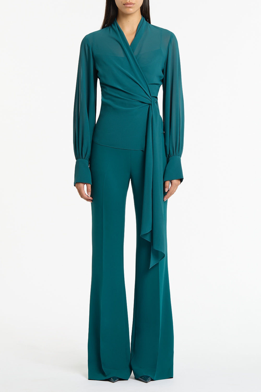 Image of a model wearing Tops. Product name - Serpentine Georgette Long Sleeve Wrap Top in Green colour by brand - Carla Zampatti