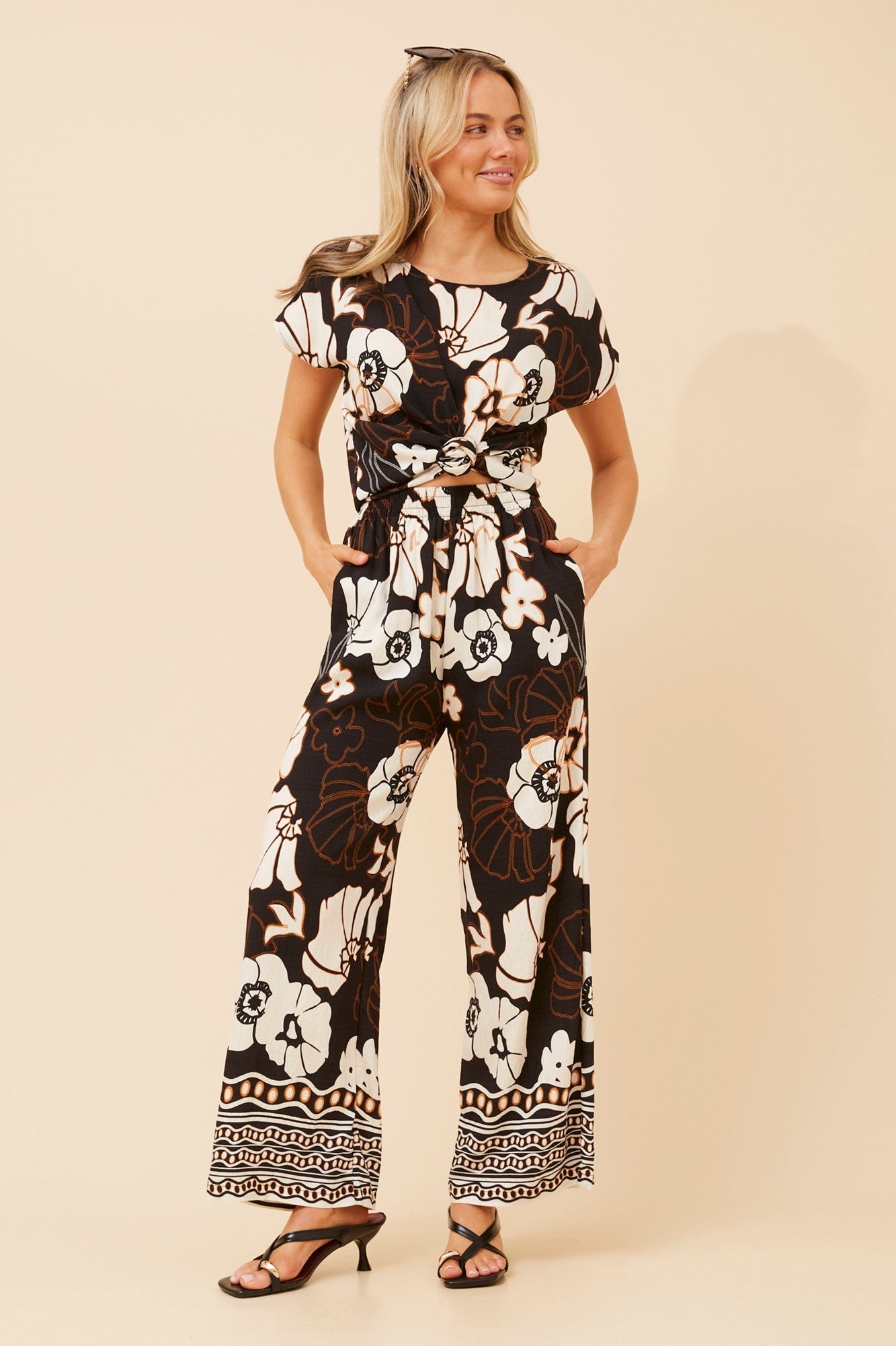 Image of a model wearing Tops. Product name - RAILEY FLORAL TWO-PIECE SET in Black colour by brand - Caroline Morgan Australia