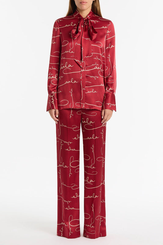 Image of a model wearing Pants. Product name - Shiraz Signature Silk Pant in Red colour by brand - Carla Zampatti