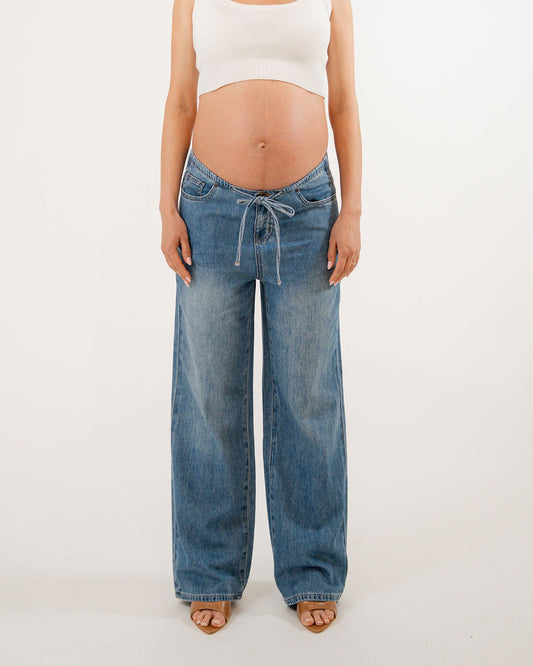 Image of a model wearing Pants. Product name - Relaxed Wide Leg Drawstring Jeans (draped) in colour by brand - Soon Maternity