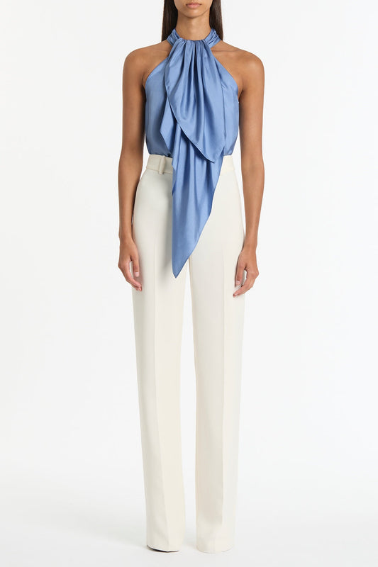 Image of a model wearing Tops. Product name - Steel Blue Silk Twill Ruffle Halter Top in Blue colour by brand - Carla Zampatti