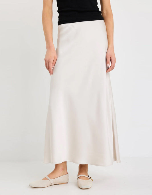 Image of a model wearing Skirts. Product name - Prodigy Satin Bias Maxi Skirt Pearl in Pearl colour by brand - Stories Be Told