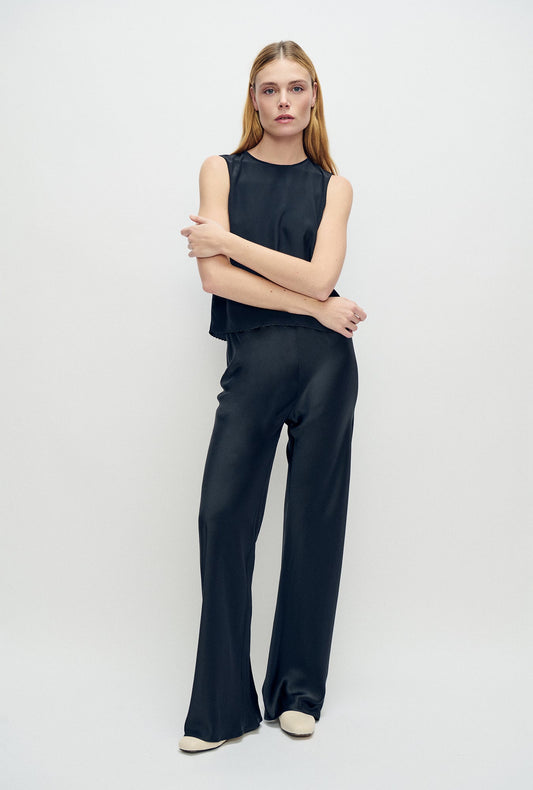 Image of a model wearing Pants. Product name - CDC Bias Cut Pants Black in Black colour by brand - Silk Laundry