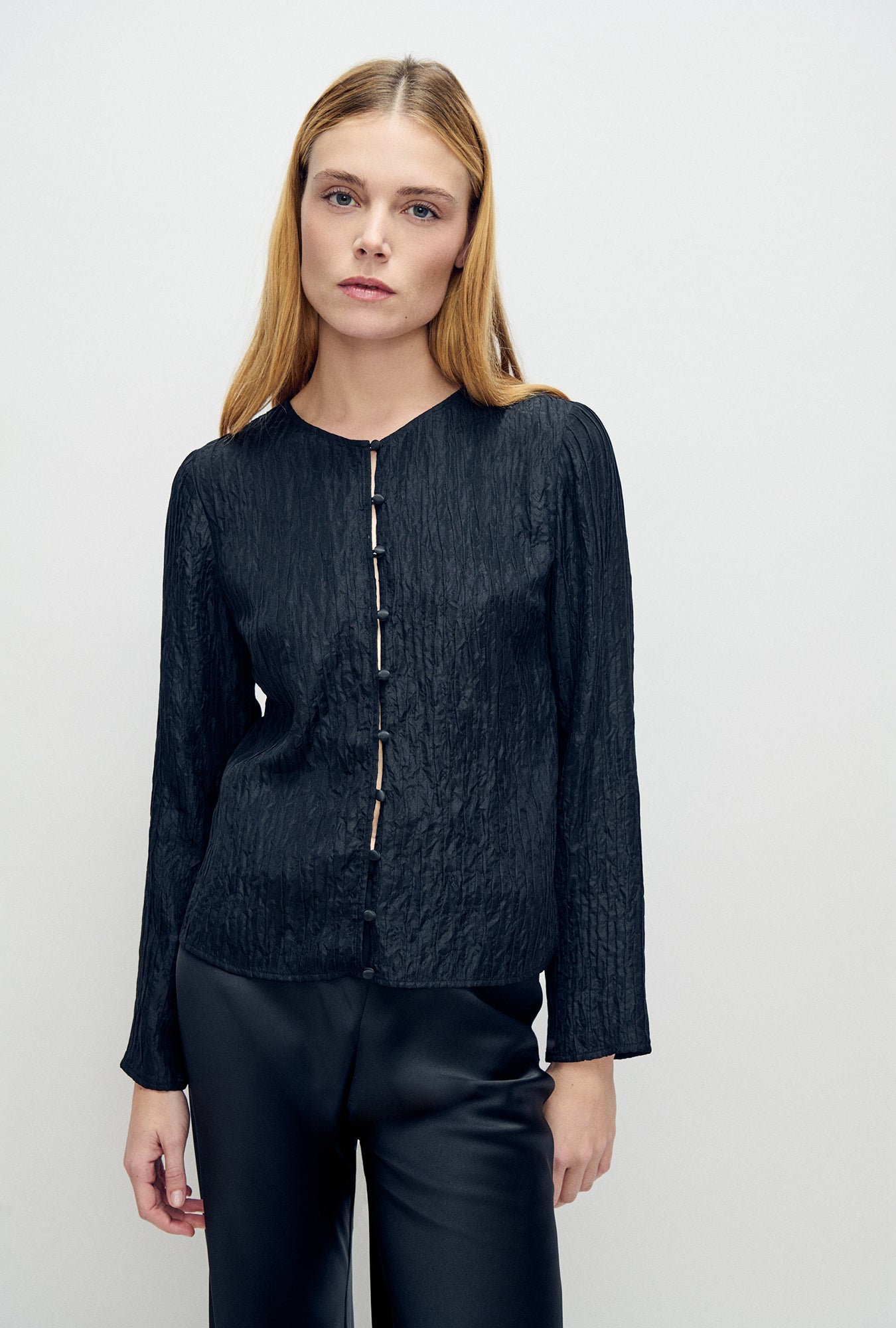 Image of a model wearing Tops. Product name - Crinkle Long Sleeve Top Black in Black colour by brand - Silk Laundry
