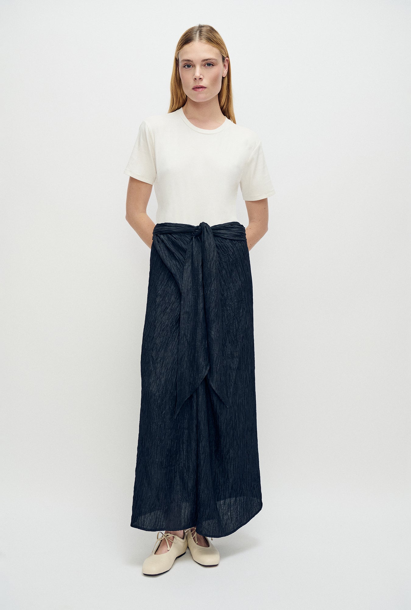 Image of a model wearing Skirts. Product name - Crinkle Twisted Wrap Skirt Black in Black colour by brand - Silk Laundry