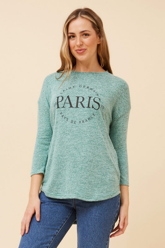 Image of a model wearing Tops. Product name - GOLDIE GRAPHIC PRINT TOP in Jade colour by brand - Caroline Morgan Australia