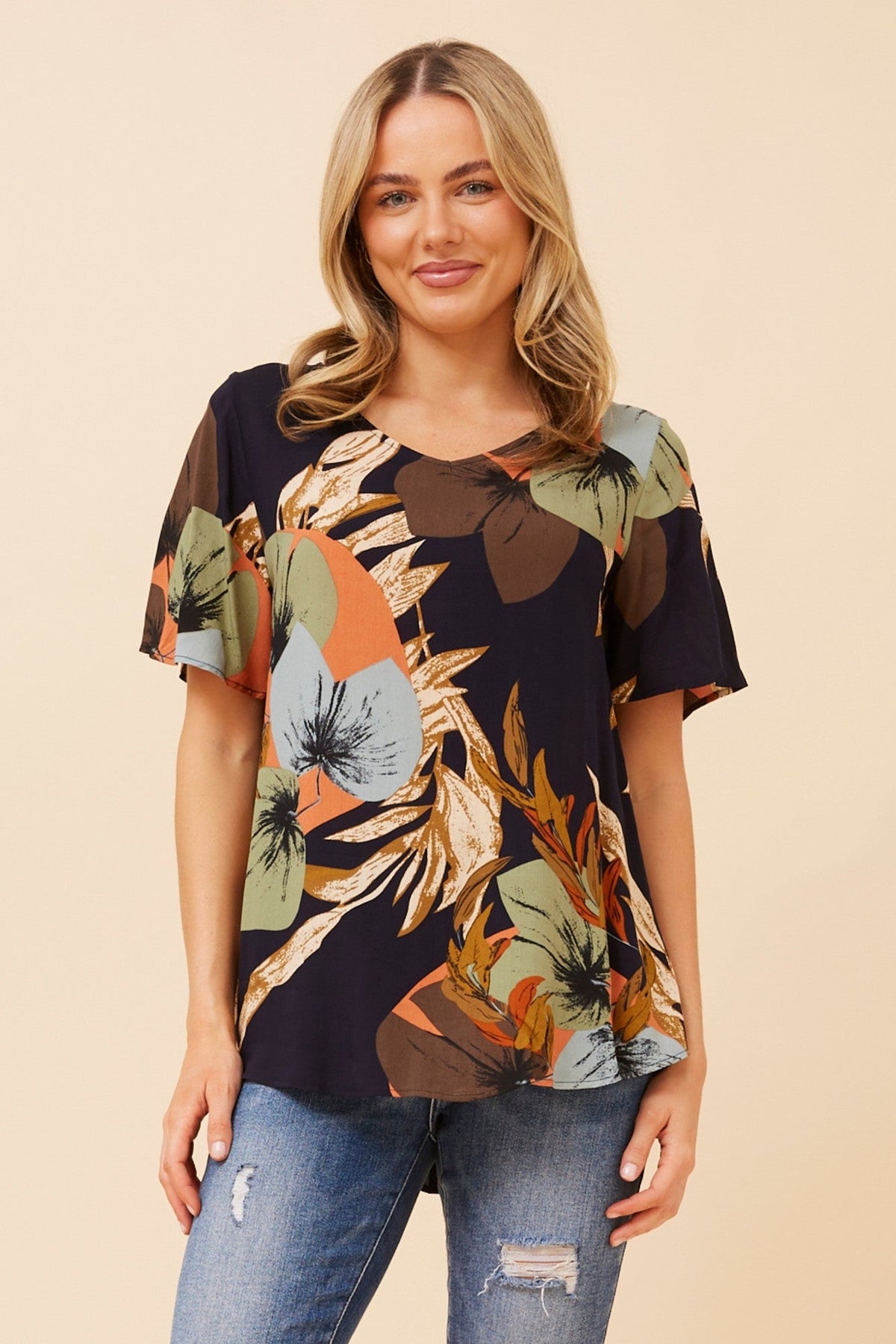 Image of a model wearing Tops. Product name - SONIA TROPICAL PRINT TOP in Navy colour by brand - Caroline Morgan Australia
