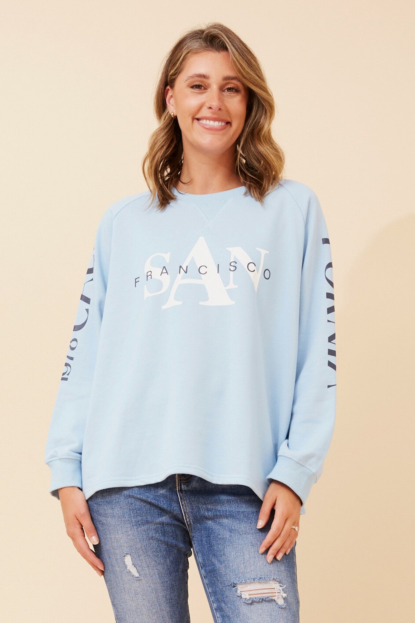 Image of a model wearing Outerwear. Product name - HUETTE GRPHIC PRINT JUMPER in Skylight colour by brand - Caroline Morgan Australia