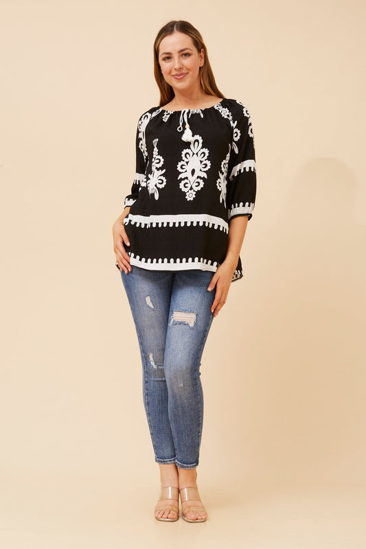 Image of a model wearing Tops. Product name - ANDREA BORDER PRINT TOP in Black colour by brand - Caroline Morgan Australia
