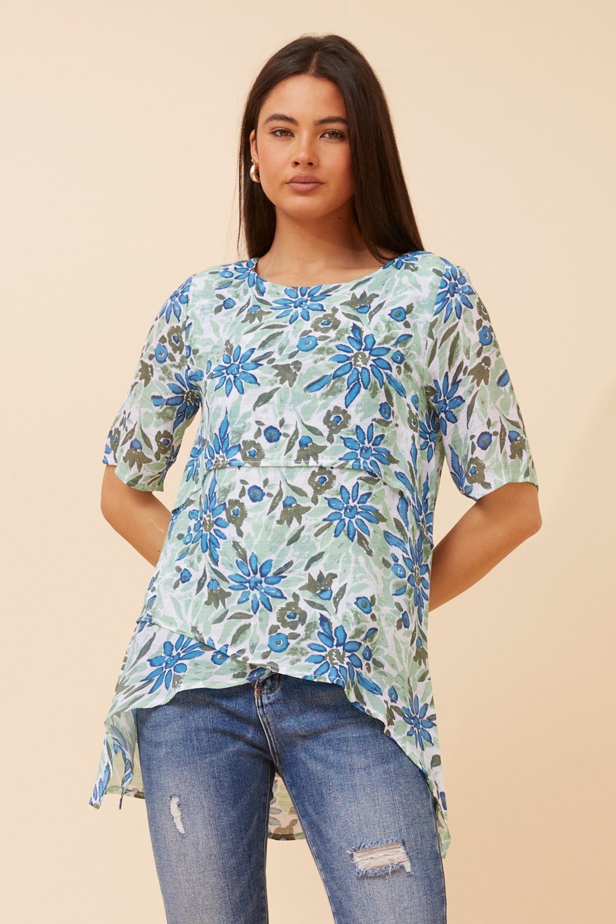 Image of a model wearing Tops. Product name - RUTH FLORAL ASYMMETRICAL TOP in Green colour by brand - Caroline Morgan Australia