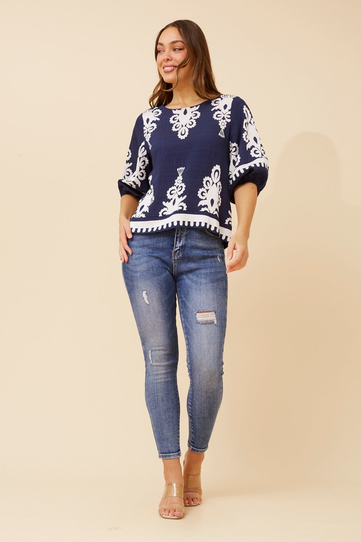 Image of a model wearing Tops. Product name - LIESL BORDER PRINT TOP in Beige colour by brand - Caroline Morgan Australia