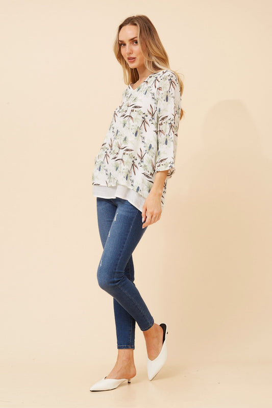 Image of a model wearing Tops. Product name - ERIANA FLORAL TOP in Multi Green colour by brand - Caroline Morgan Australia