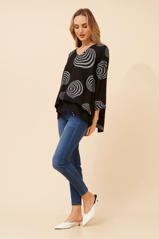 Image of a model wearing Tops. Product name - LORETO ABSTRACT PRINT TOP in Black colour by brand - Caroline Morgan Australia