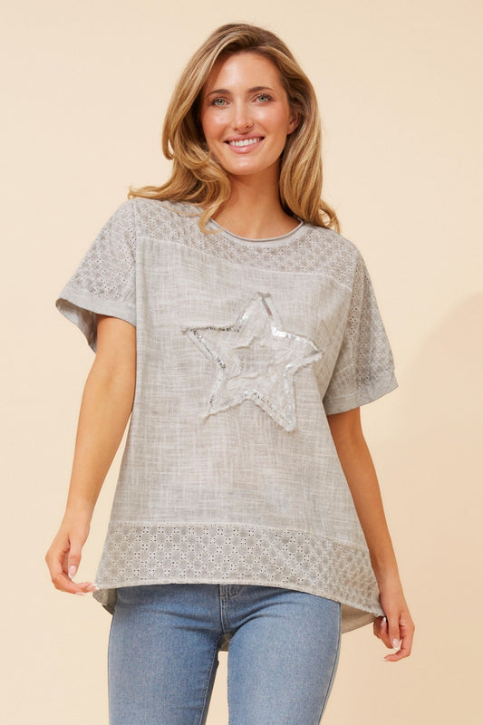 Image of a model wearing Tops. Product name - DRAI SEQUIN STAR TOP in Light Blue colour by brand - Caroline Morgan Australia