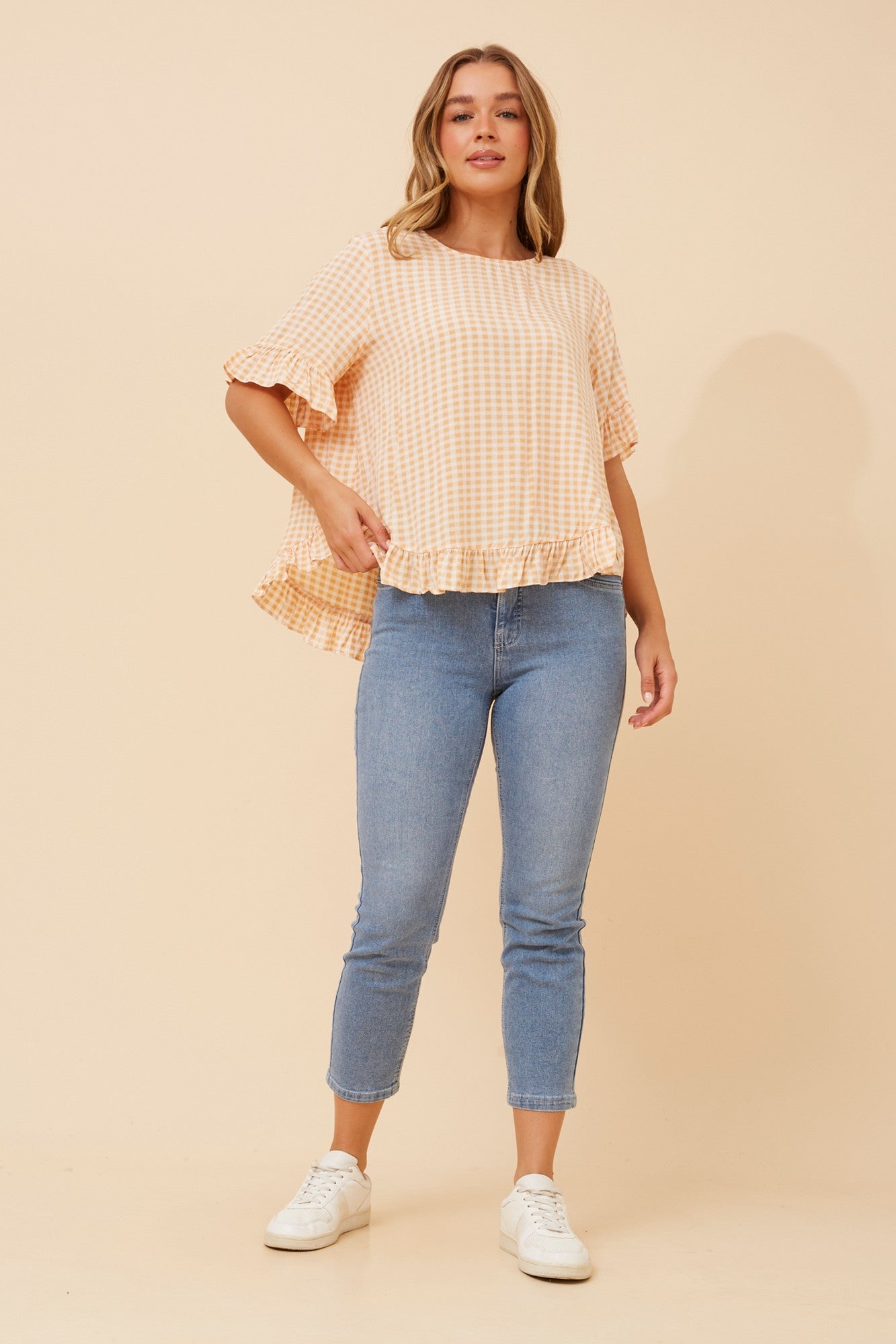 Image of a model wearing Tops. Product name - FRILA GINGHAM PRINT FRILL TOP in Marigold colour by brand - Caroline Morgan Australia