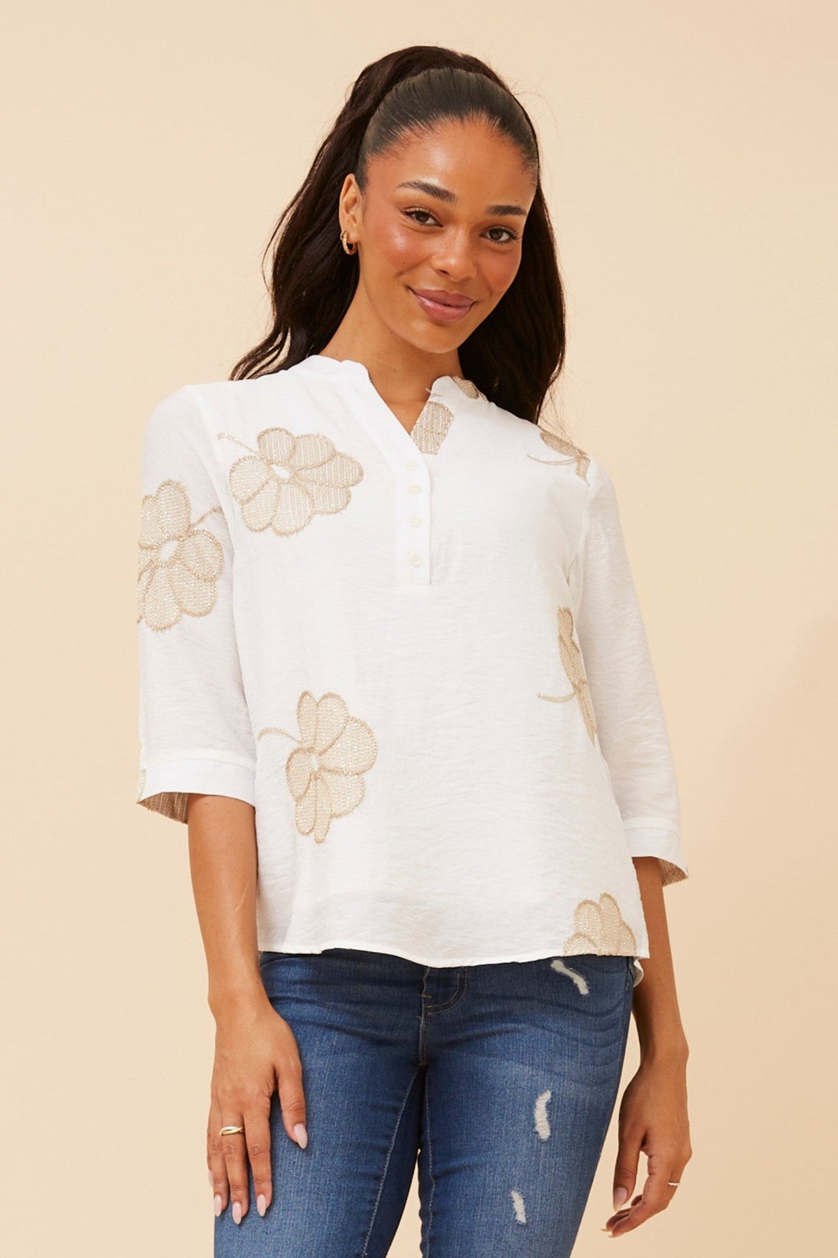 Image of a model wearing Tops. Product name - NORNAH EMBROIDERED TOP in White colour by brand - Caroline Morgan Australia