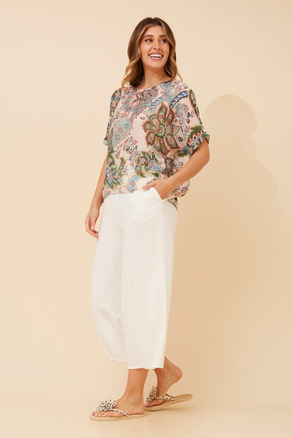 Image of a model wearing Tops. Product name - HENDRIX FLORAL TOP in Multi Blue colour by brand - Caroline Morgan Australia