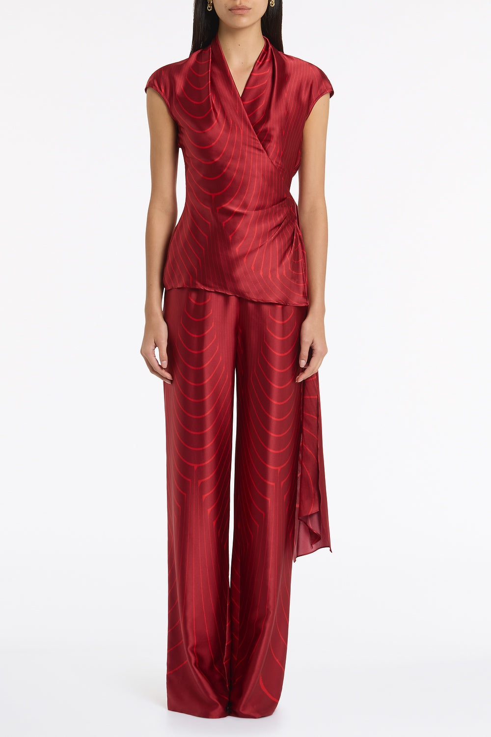 Image of a model wearing Tops. Product name - Undercurrent Silk Viscose Stretch Cap Sleeve Wrap Top in Red colour by brand - Carla Zampatti