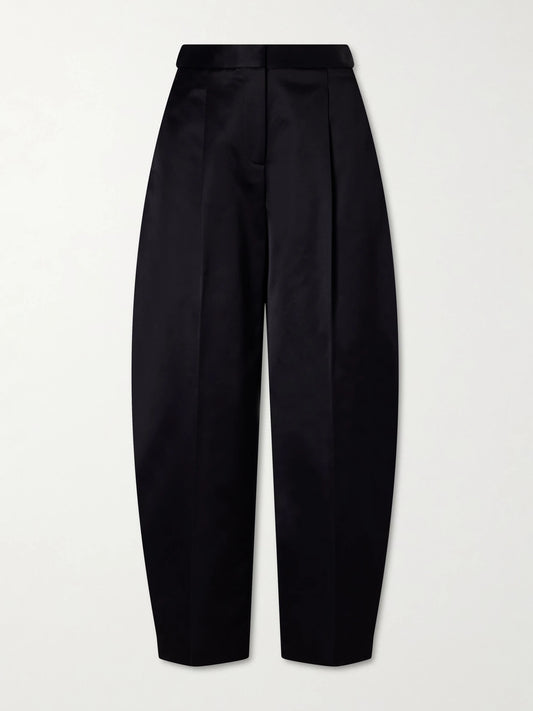 Image of a model wearing Pants. Product name - Pleated Cotton-blend Tapered Pants in Black colour by brand - Alaïa