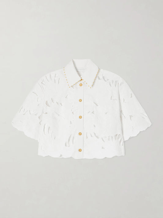 Image of a model wearing Tops. Product name - Mahon Cropped Embroidered Cotton Top in Ivory colour by brand - Zimmermann