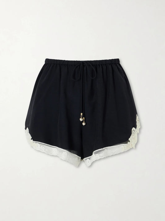 Image of a model wearing Shorts. Product name - Roselight Lace-trimmed Cotton And Silk-blend Shorts in Black colour by brand - Zimmermann