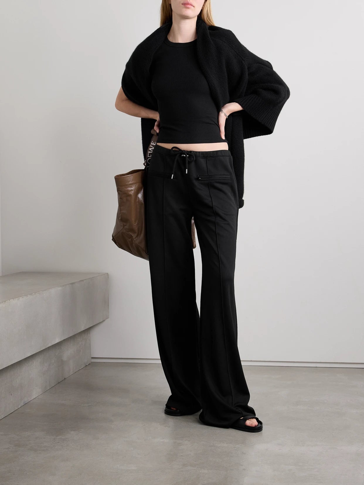 Image of a model wearing Tops. Product name - Kelly Ribbed Cotton-blend Jersey T-shirt in Black colour by brand - LESET