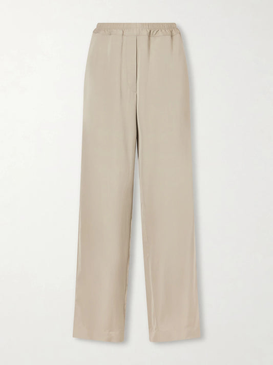 Image of a model wearing Pants. Product name - Duvain Silk Straight-leg Pants in Cream colour by brand - The Row