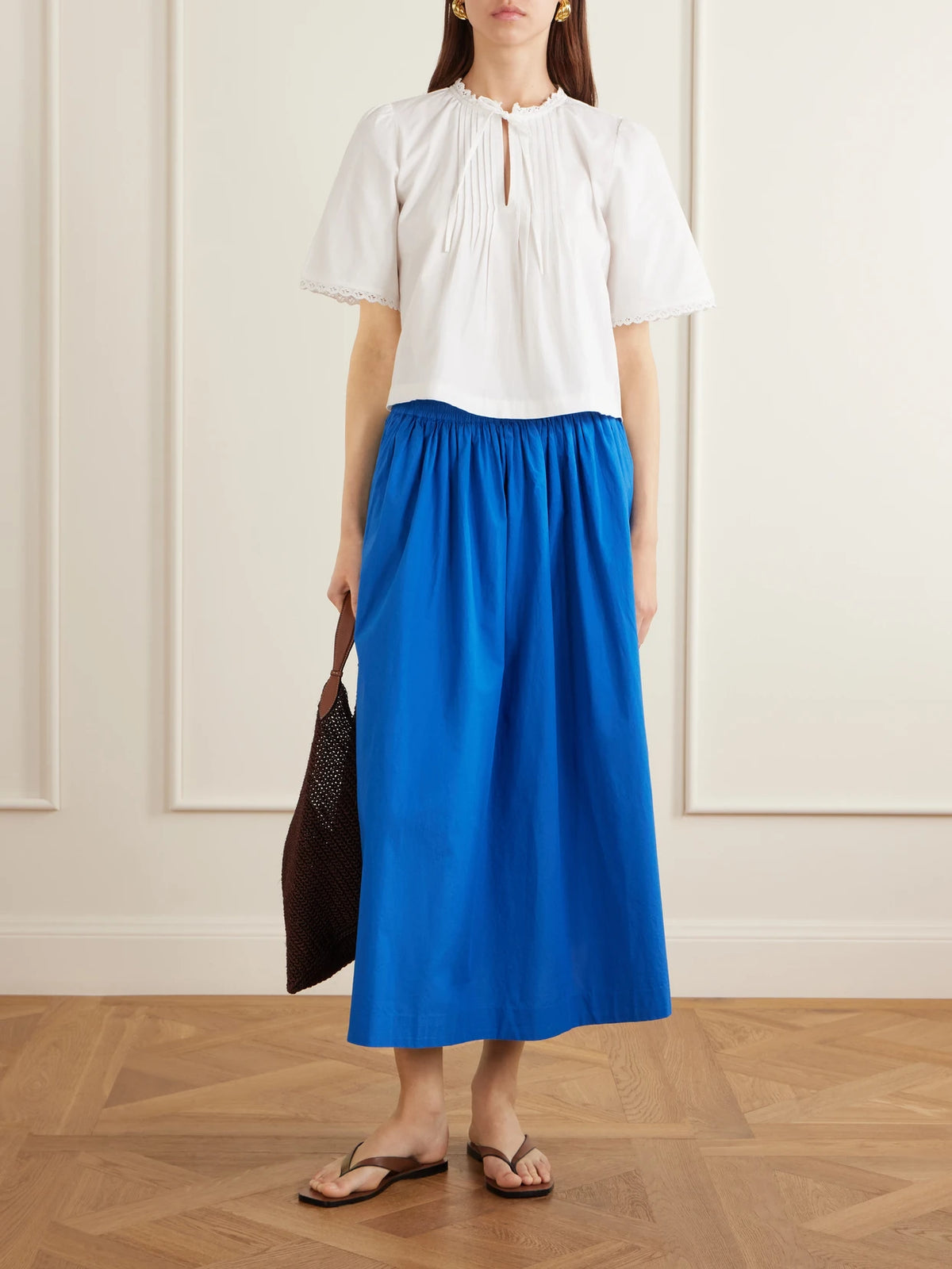 Image of a model wearing Tops. Product name - Freesia Pleated Lace-trimmed Organic Cotton Shirt in White colour by brand - SKALL
