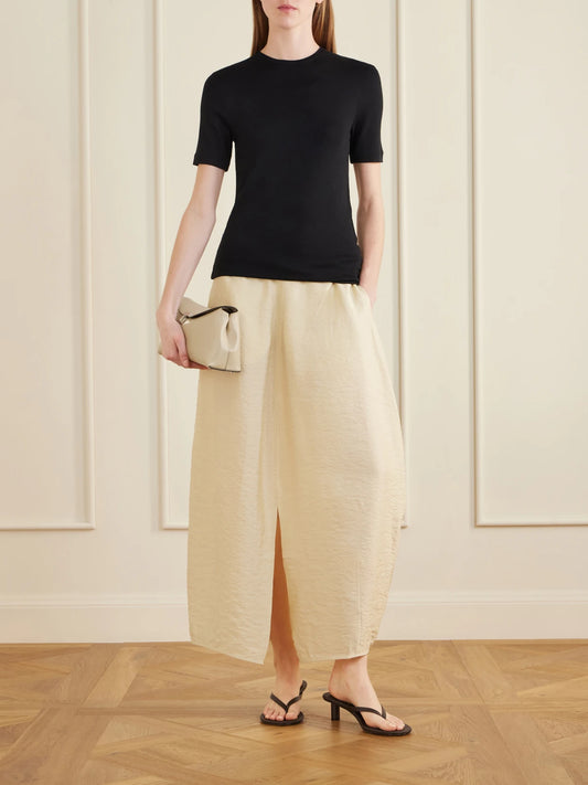 Image of a model wearing Skirts. Product name - Silk-blend Maxi Skirt in Beige colour by brand - TOTEME