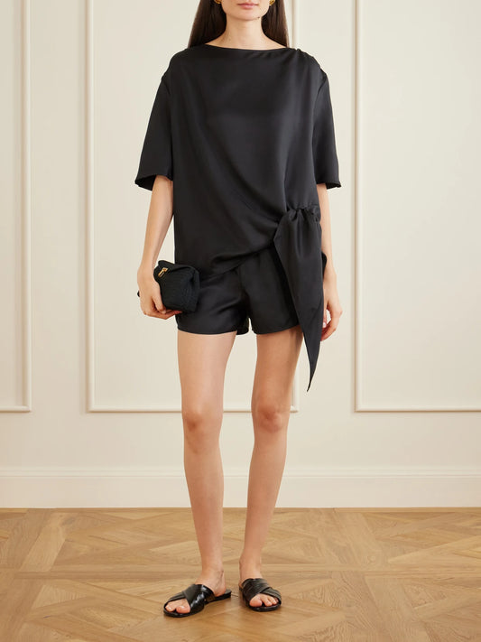 Image of a model wearing Shorts. Product name - Cabo Silk Shorts in Black colour by brand - Loulou de Saison