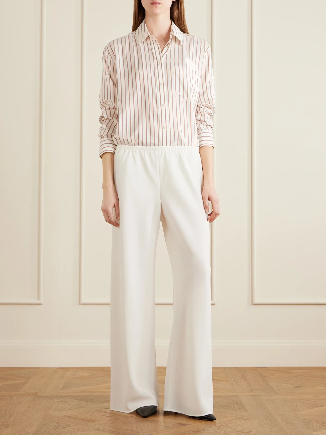Image of a model wearing Pants. Product name - Gala Cady Wide-leg Pants in Off-white colour by brand - The Row
