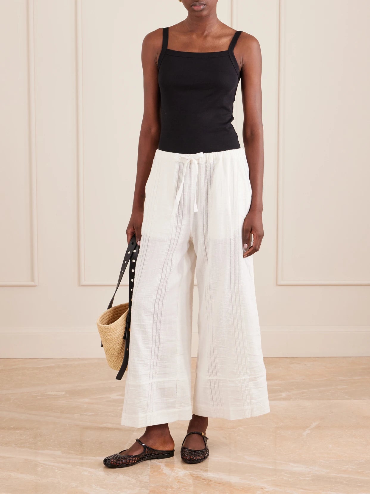 Image of a model wearing Pants. Product name - Desta Striped Cotton Wide-leg Pants in White colour by brand - lemlem
