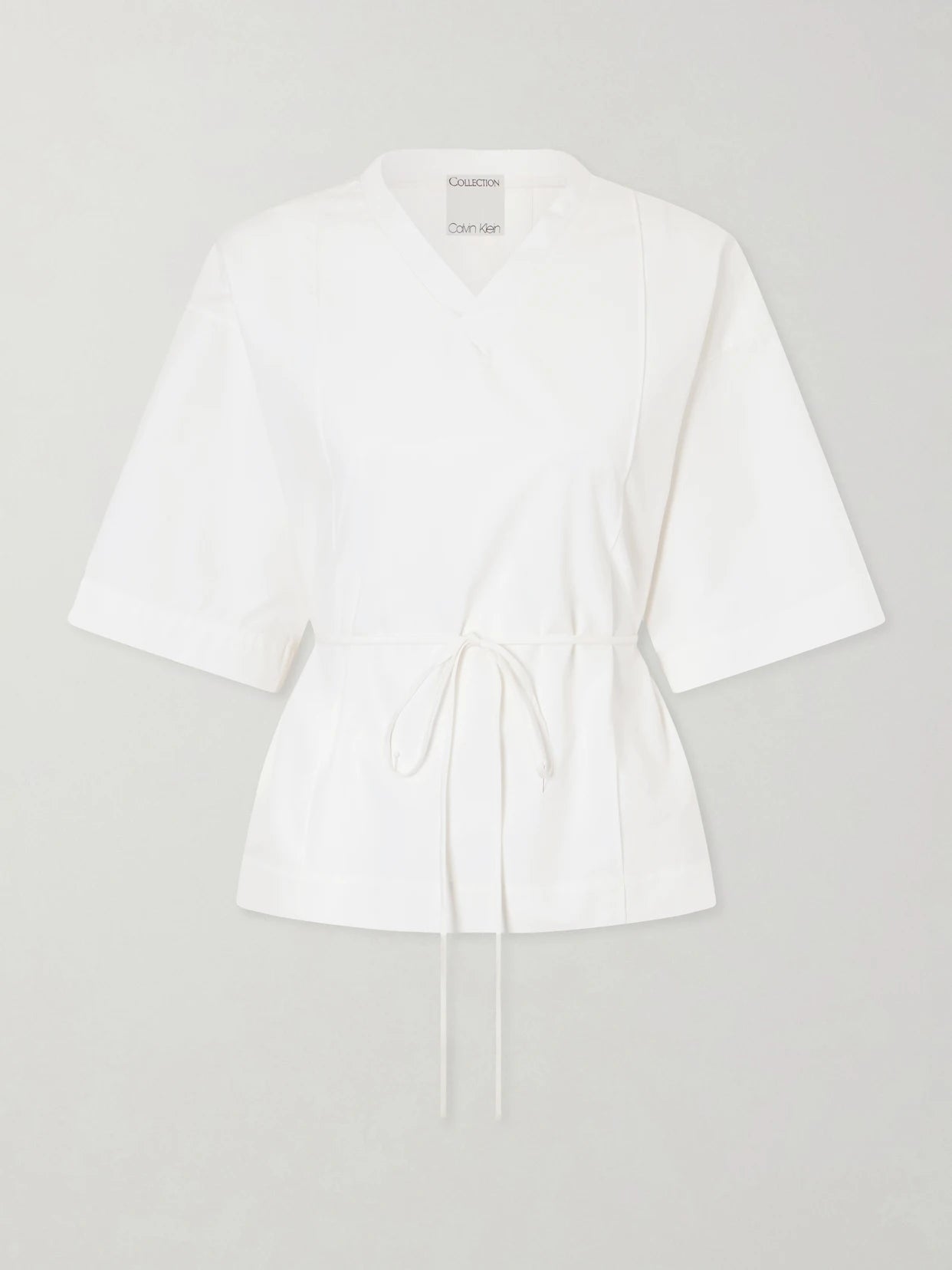 Image of a model wearing Tops. Product name - Lynn Cotton-poplin Wrap Blouse in Off-white colour by brand - Calvin Klein Collection