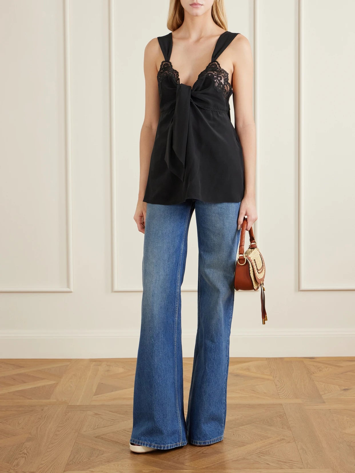 Image of a model wearing Tops. Product name - Knotted Lace-trimmed Silk Crepe De Chine Tank in Black colour by brand - Chloé