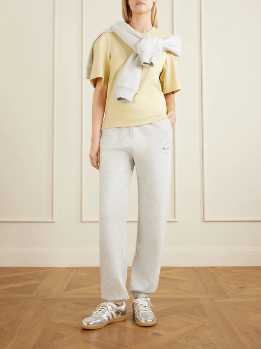 Image of a model wearing Tops. Product name - Beverly Script Cotton-jersey Track Pants in Gray colour by brand - Sporty & Rich