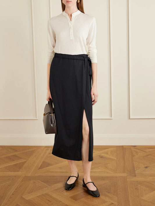 Image of a model wearing Skirts. Product name - Organic Cotton And Silk-blend Wrap Midi Skirt in Black colour by brand - TOTEME