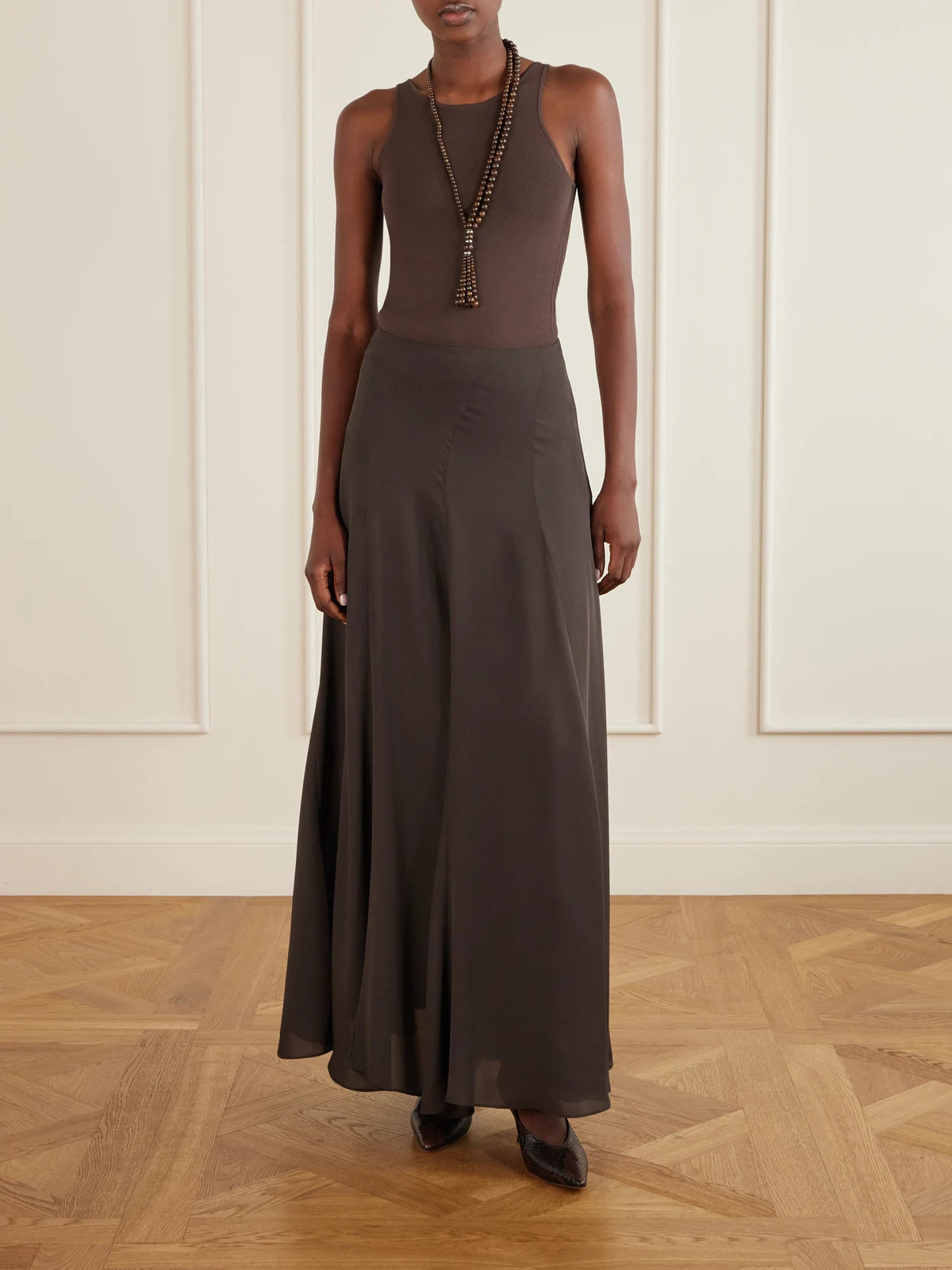 Image of a model wearing Skirts. Product name - Aeris Pleated Silk-crepe Midi Skirt in Dark brown colour by brand - Ruohan