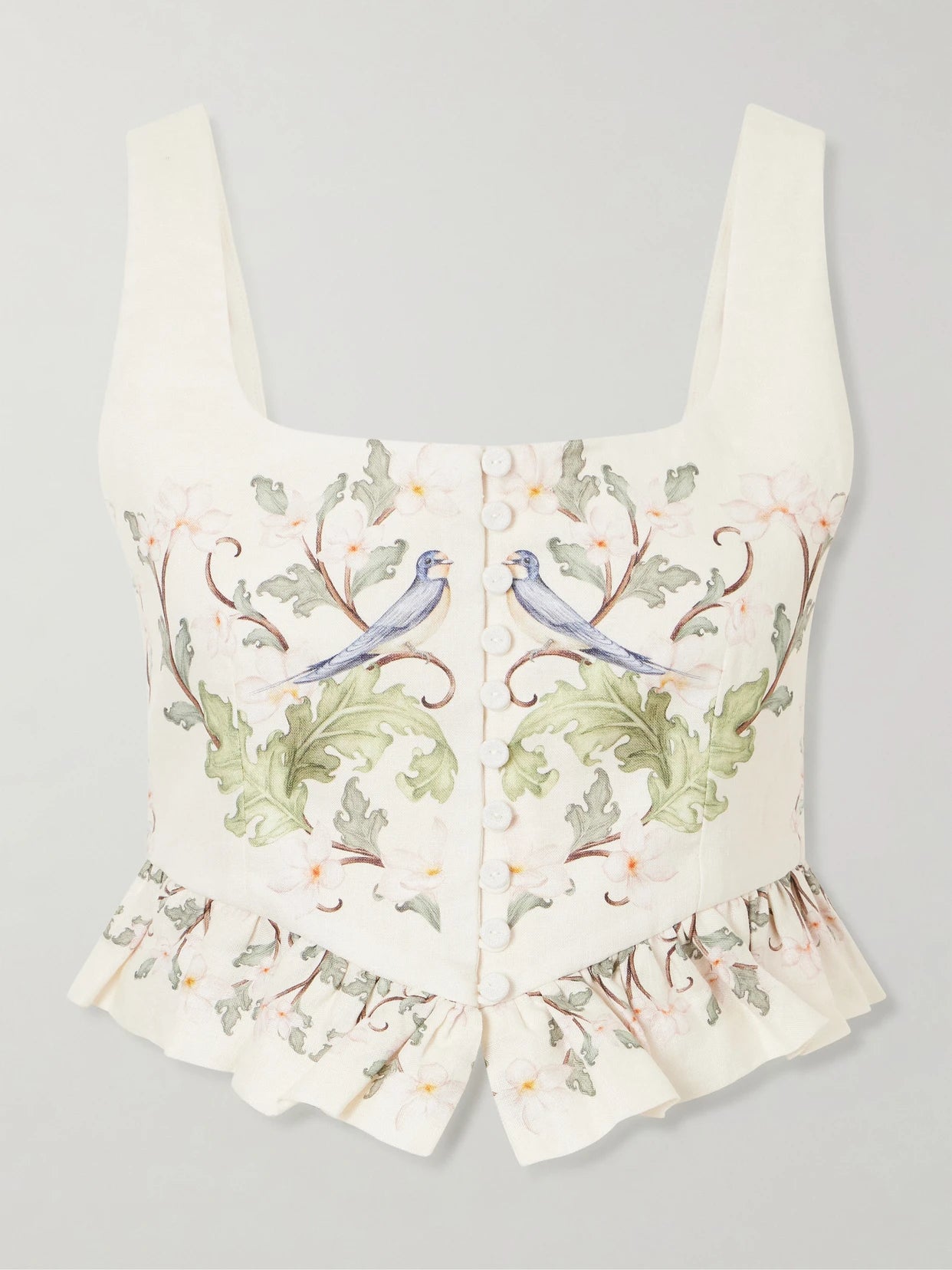 Image of a model wearing Tops. Product name - Eslabon Anhelo Floral-print Button-embellished Linen Cropped Top in Cream colour by brand - Agua by Agua Bendita