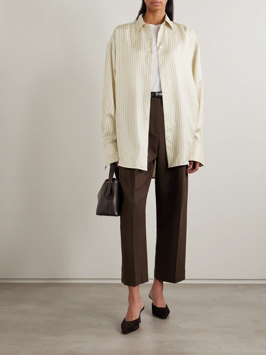Image of a model wearing Tops. Product name - Oversized Striped Silk Shirt in Beige colour by brand - TOTEME