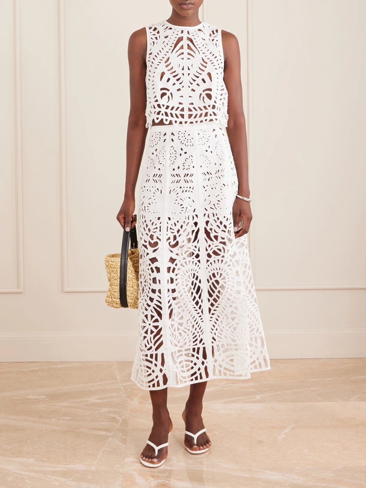 Image of a model wearing Skirts. Product name - Rita Brisé Embroidered Cotton Midi Skirt in White colour by brand - Emporio Sirenuse