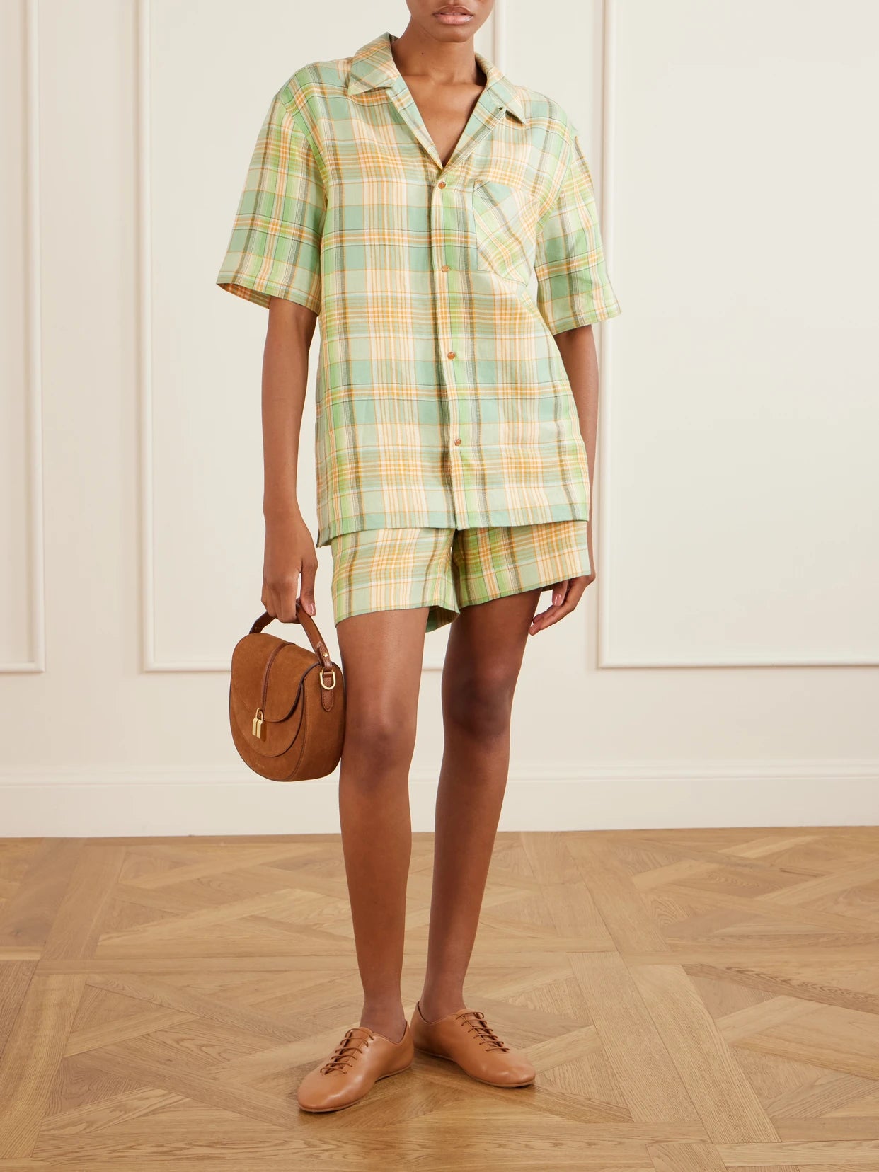 Image of a model wearing Shorts. Product name - Lime Moss Checked Linen Shorts in Green colour by brand - God's True Cashmere